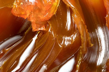 Turuncu renkli endüstriyel yağları kapatın. Metal sürtünmeyi yumuşatmak için kullanılan zengin ve kalın endüstriyel yağ dokusu. Kayganlaştırıcı yağ. Makine için sarı lityum yağı yakın çekim