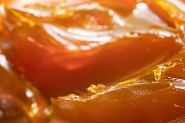 Turuncu renkli endüstriyel yağları kapatın. Metal sürtünmeyi yumuşatmak için kullanılan zengin ve kalın endüstriyel yağ dokusu. Kayganlaştırıcı yağ. Makine için sarı lityum yağı yakın çekim