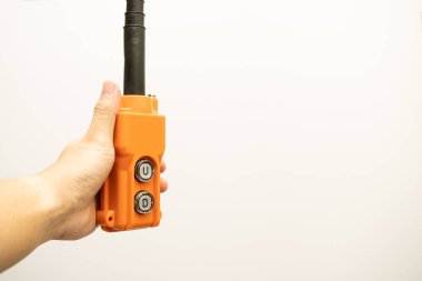 Hoist push button switch in isolated. hand holding overhead cranes remote. Up Down hydraulic controller switch. electric remote push button switch of hoist lift or crane for control direction.