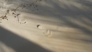 footage of sea waves wahing off footprints on the golden sand at beach. Footmarks on the sand washed up