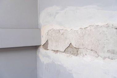 house broken. concrete crack. Water damage building interior. large crack white concrete wall