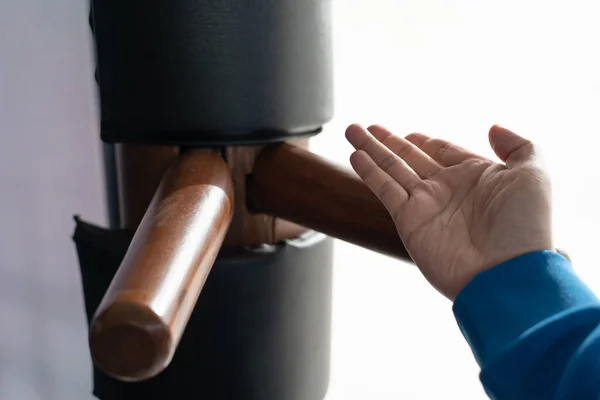 The athlete shows techniques Wing-Chun Kung-Fu wooden dummy. Wing Chun Kung Fu Self defense. Training in the art of self-defense