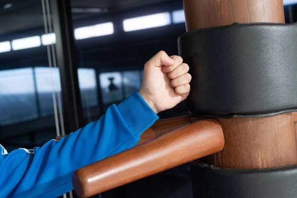 The athlete shows techniques Wing-Chun Kung-Fu wooden dummy. Wing Chun Kung Fu Self defense. Training in the art of self-defense