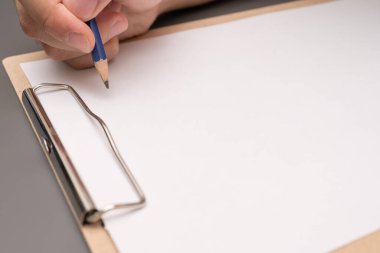 hand writing on clipboard. Stationery. write a note on empty blank with a pencil