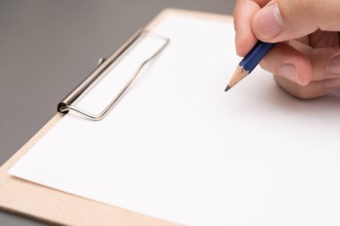 hand writing on clipboard. Stationery. write a note on empty blank with a pencil