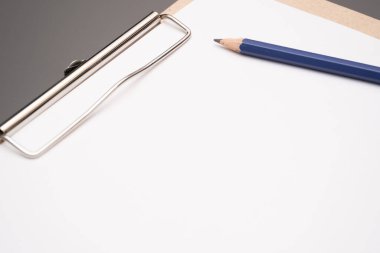 a clipboard with a white sheet of paper