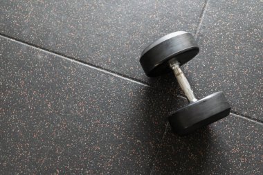 Black dumbbell. Weight Training Equipment. black dumbbells on the floor in dark concept fitness room with training equipments
