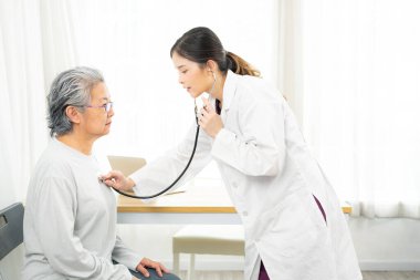 Yandan bakan kadın doktor steteskop kullanıyor, olgun hasta akciğerlerini kontrol ediyor, kalp atışlarını dinliyor, yaşlı kadın nefesi dinliyor, yaşlı nesil sağlık hizmetleri, tıbbi kontrol kavramı. tıbbi sigorta kavramı