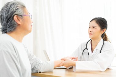 Doktor yaşlı hastasının nabzını kontrol ediyor..