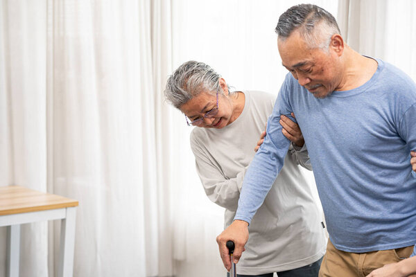 senior woman support senior older male to walk. Elderly wife taking good help care and support of elder husband. selective focus.