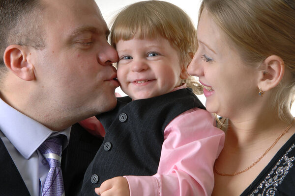 портрет счастливой семьи: мать и отец смотрят на своего милого сына