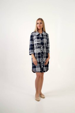 Güzel sarışın kız beyaz arka planda gündelik kıyafetlerle poz veriyor. İzole edilmiş stüdyo resmi.                    