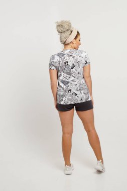 Güzel sarışın kız beyaz arka planda gündelik kıyafetlerle poz veriyor. İzole edilmiş stüdyo resmi.                    