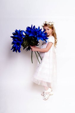 Mavi çiçekli güzel bir kız çocuğu. Stüdyoda izole edilmiş.