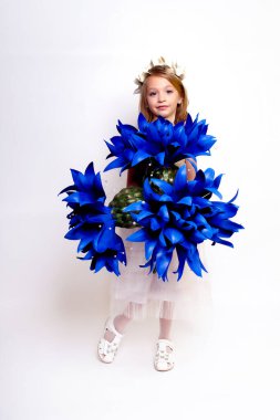 Mavi çiçekli güzel bir kız çocuğu. Stüdyoda izole edilmiş.
