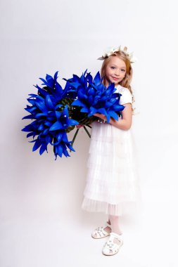 Mavi çiçekli güzel bir kız çocuğu. Stüdyoda izole edilmiş.