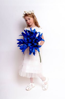 Mavi çiçekli güzel bir kız çocuğu. Stüdyoda izole edilmiş.