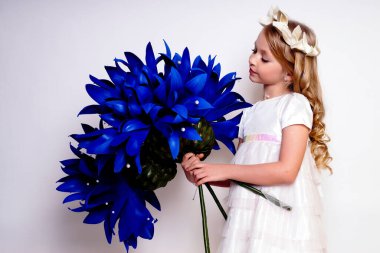 Mavi çiçekli güzel bir kız çocuğu. Stüdyoda izole edilmiş.