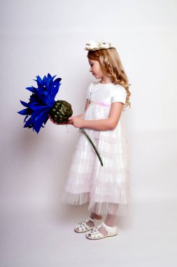 Mavi çiçekli güzel bir kız çocuğu. Stüdyoda izole edilmiş.