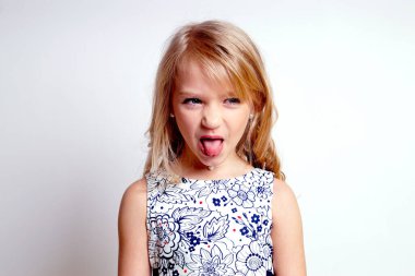 Gri elbiseli güzel bir kız çocuğu. Issız bir stüdyo fotoğrafı.