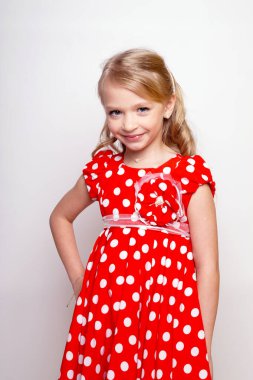 Kırmızı elbiseli, hediye kutusu olan güzel bir kız çocuğu. Issız stüdyo fotoğrafı.