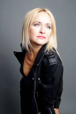 Beyaz arka planda siyah ceketli kadın. Issız bir stüdyo fotoğrafı.