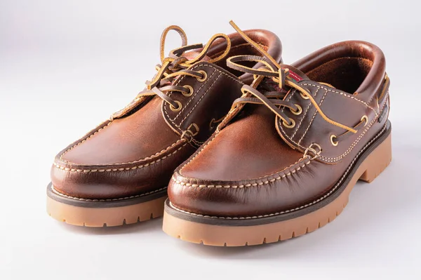 Beyaz arka planda izole edilmiş kahverengi deri mokasen ayakkabılar.