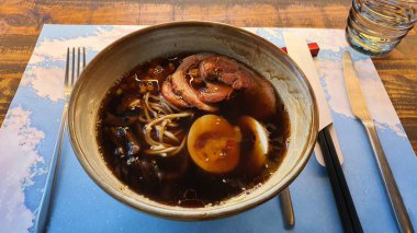 Ukrayna 'da bir restoranda akşam yemeği. Büyük bir kase ramen çorbası. Erişte, et ve yumurtalı makarna.
