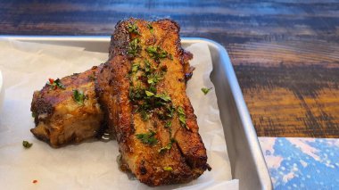 İki parça lezzetli pirzola. Tabağa otlar serpiştirilmiş.