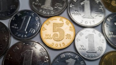 Ortada bir sürü Çin sikkesi var. 5-jiao sikkesi. 5 Jiao sikkesi yakın planda atılıyor. Arka planda, bir yuan, bir ve beş jiao 'nun birkaç sikkesi var.