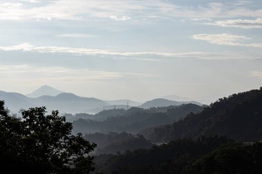 Karmaşık dağlar, sabah sisi ve sıcak güneş ışığı