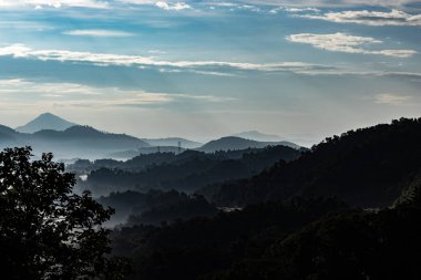 Karmaşık dağlar, sabah sisi ve sıcak güneş ışığı
