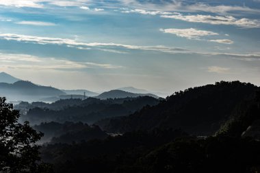 Karmaşık dağlar, sabah sisi ve sıcak güneş ışığı