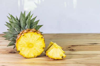 Tahta bir masada dilimlenmiş ananas. Tatlı ve ekşi meyveleri yakın ve yüksek vitaminli.