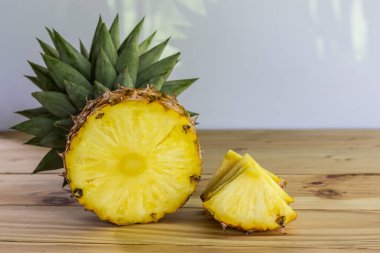 Tahta bir masada dilimlenmiş ananas. Tatlı ve ekşi meyveleri yakın ve yüksek vitaminli.