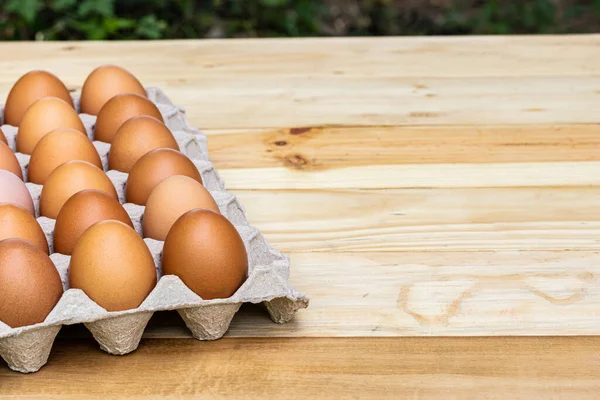 chicken eggs in carton box, on wooden table, nutritious food, close-up photo of eggs in tray