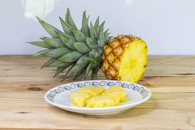 Tahta bir masada dilimlenmiş ananas. Tatlı ve ekşi meyveleri yakın ve yüksek vitaminli.