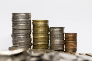 Pile of coins in white background, close-up, arranged in a row