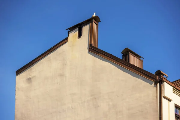 Eski şehir merkezinde mavi gökyüzü olan eski beyaz bir bina.