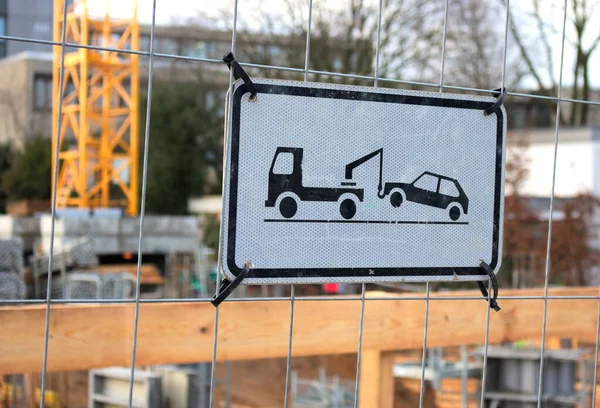 A warning sign at a construction site fence in Hamburg. Parking is forbidden in front of the site.