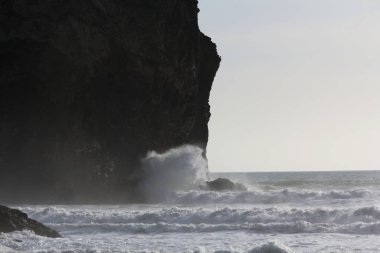 Trebarwith Strand, Martı Kayası 'nın bulunduğu kuzey Cornwall Kıyı şeridi boyunca Tintagel' den sadece 3 km uzaklıktadır. Kumlu sahil gelgitte tamamen kaplanır. Bu fotoğraf kayaların üzerinde kırılan bir dalgayı gösteriyor..
