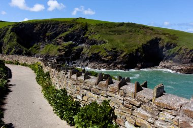 Tintagel Kalesi, Cornwall 'ın batı kıyısındaki Tintagel köyünden çok uzak olmayan bir yarımadada yer almaktadır. Dik girişler ve çıkışlar ona götürür, sadece dar bir kara diliyle anakaraya bağlıdır..