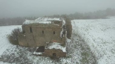 Terk edilmiş, bakımsız bir manastırın hava görüntüsü. Dışarıda kar yağıyor. Adı Convento dei Frati Cappuccini ve 16. yüzyıldan kalma. Grottole, Güney İtalya 'da yer almaktadır..