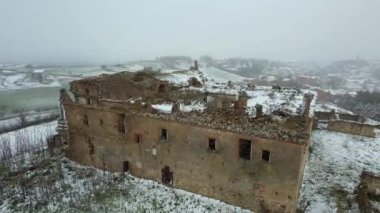 Terk edilmiş, bakımsız bir manastırın hava görüntüsü. Dışarıda kar yağıyor. Adı Convento dei Frati Cappuccini ve 16. yüzyıldan kalma. Grottole, Güney İtalya 'da yer almaktadır..