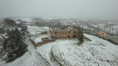 Terk edilmiş, bakımsız bir manastırın hava görüntüsü. Dışarıda kar yağıyor. Adı Convento dei Frati Cappuccini ve 16. yüzyıldan kalma. Grottole, Güney İtalya 'da yer almaktadır..