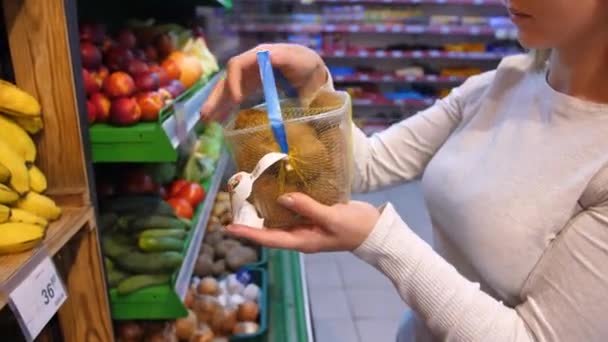 一个女孩买了一个猕猴桃 食品杂货店 天然水果和蔬菜 商店里的异国货 — 图库视频影像