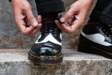 Erkeklerin el yapımı, hakiki deri ayakkabılarının yakından görüntüsü. Erkekler takılırken ayakkabılarını lastikle bağlar.