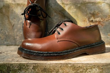 Kahverengi 3 delikli botlar el yapımı ayakkabı ustaları tarafından, bu ayakkabılar zarif ve büyüleyici görünüyor.