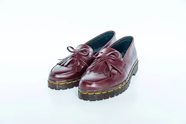 Maroon tassel shoes with rubber soles handcrafted by local craftsmen, photographed on a white background