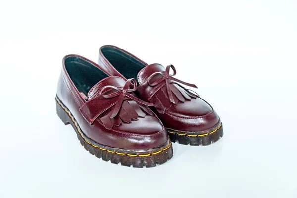 Maroon tassel shoes with rubber soles handcrafted by local craftsmen, photographed on a white background